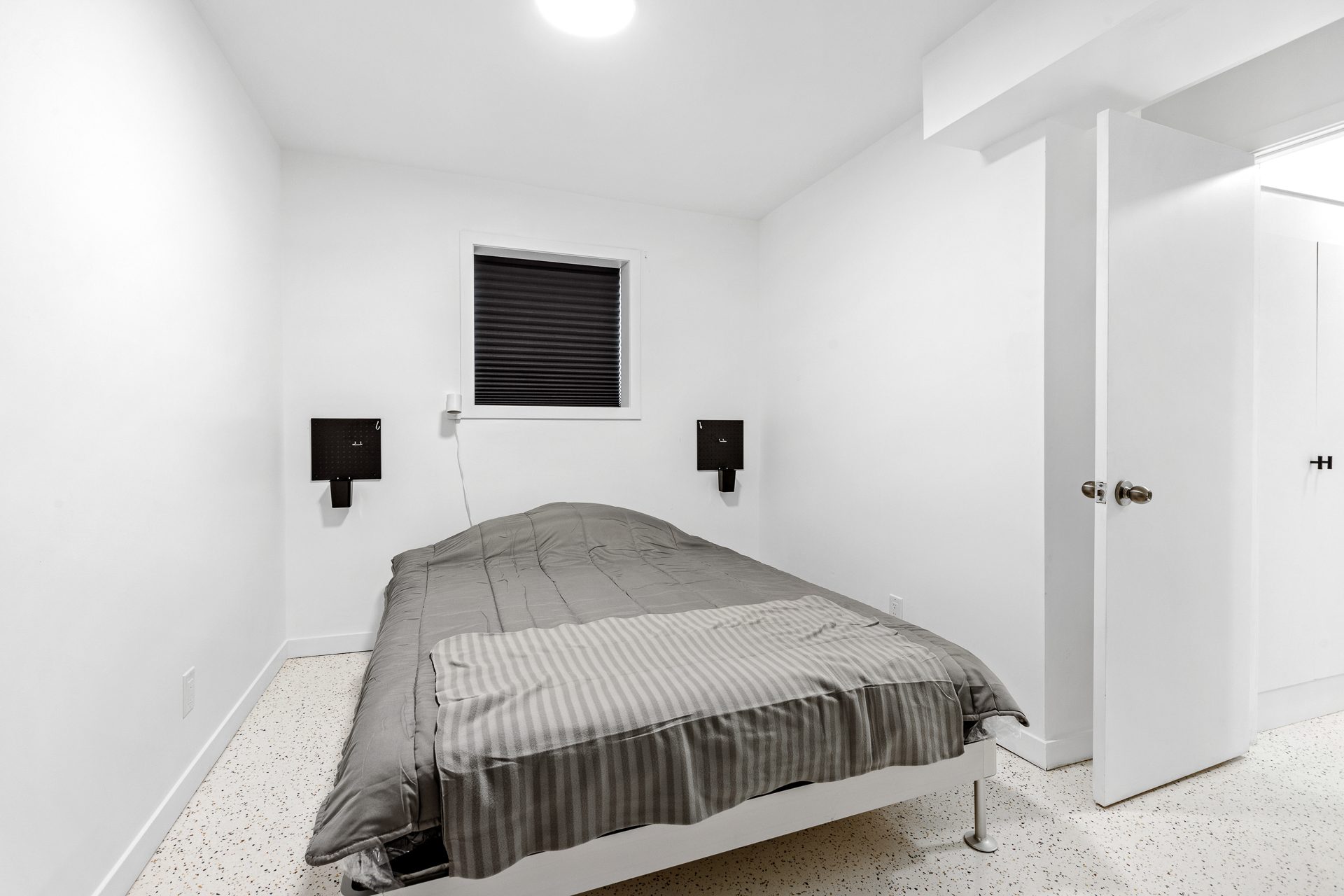 Unit 06 bedroom with bed facing the window and doorway