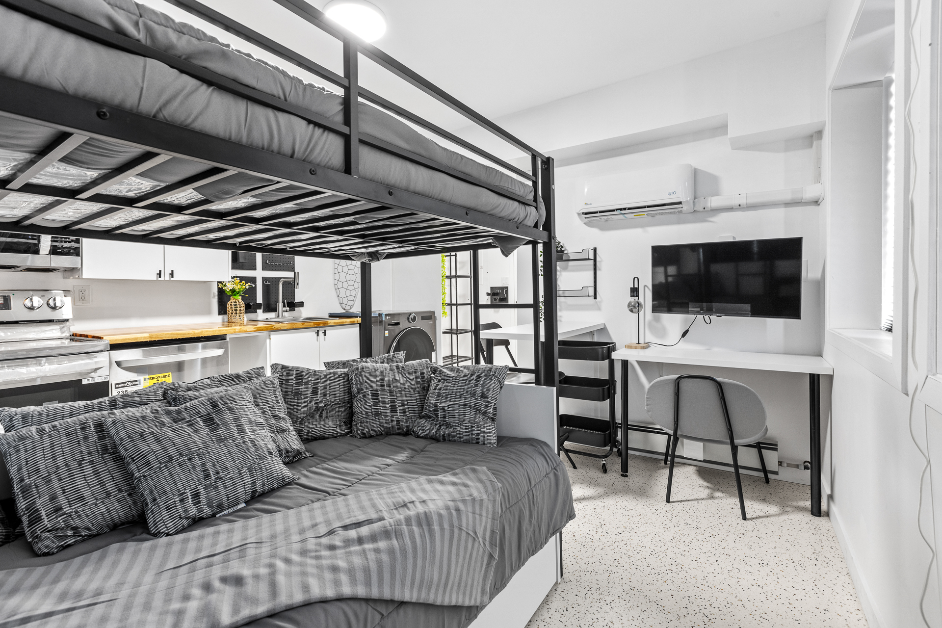 Unit 09 living and sleeping zone with loft bed, daybed, and desk