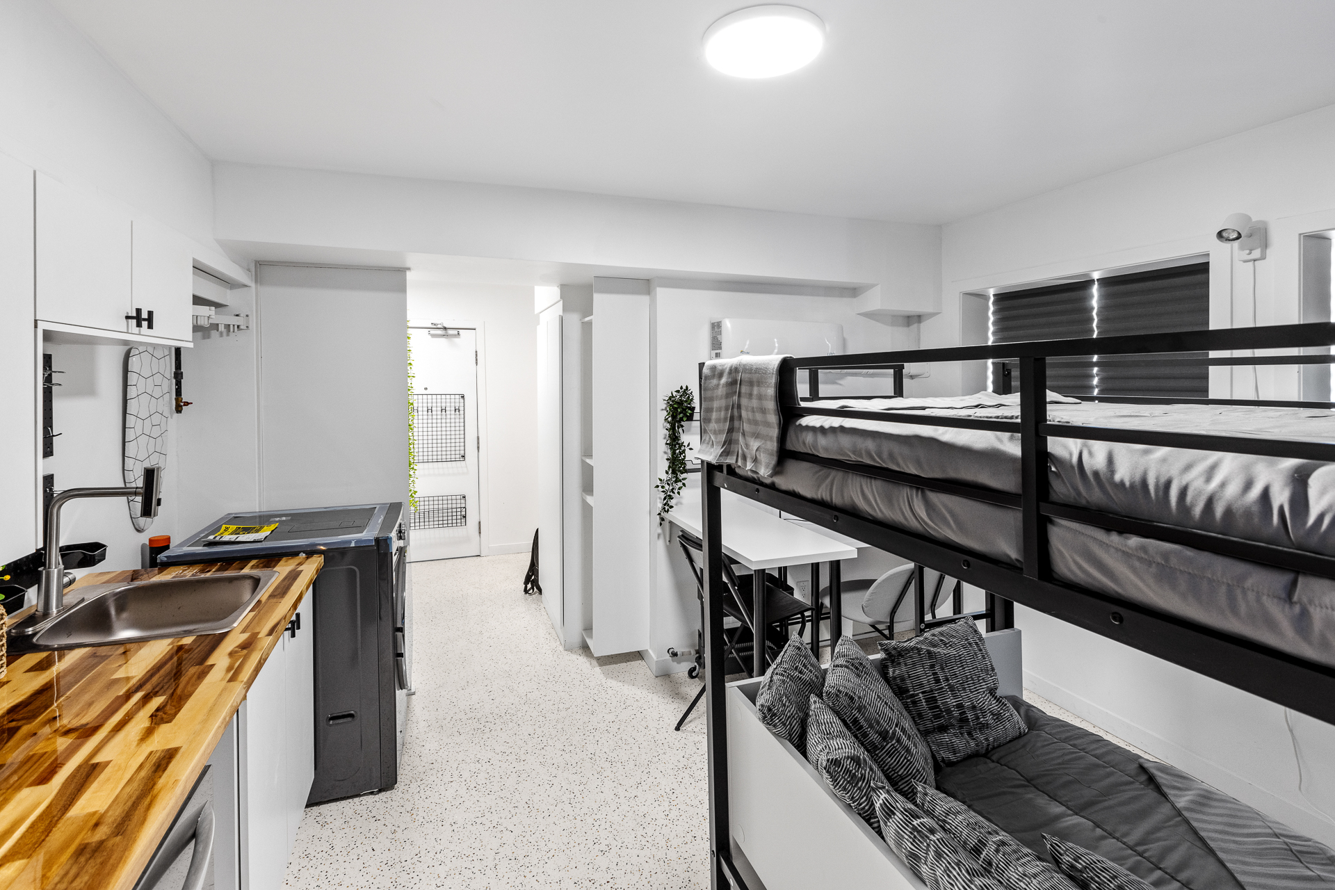 Unit 09 kitchen wall with range, sink, and cabinetry