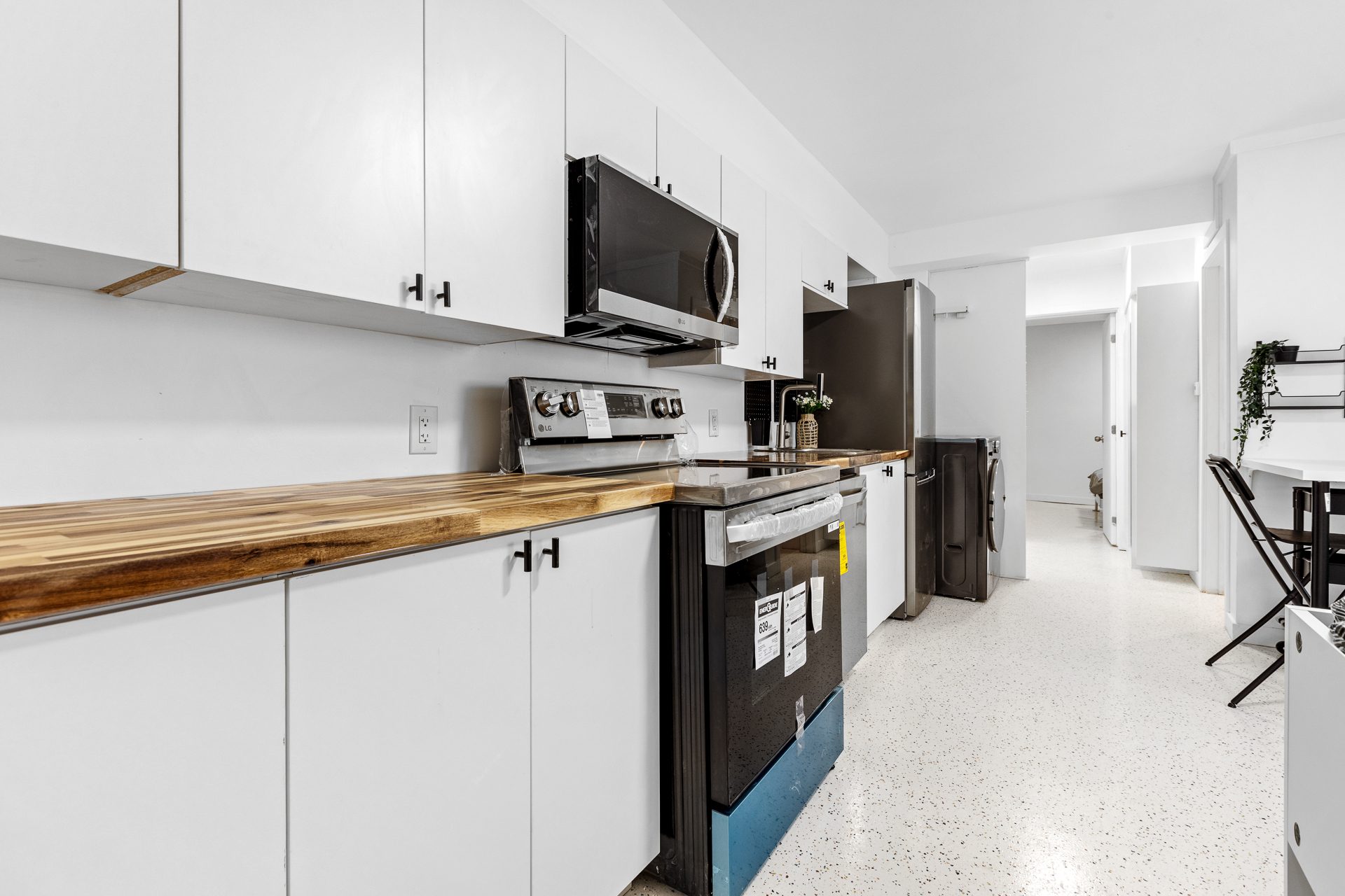 Unit 06 galley kitchen with butcher block counters and black appliances